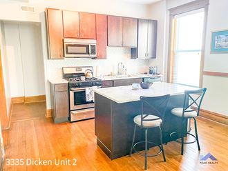 a kitchen with a large island and stainless steel appliances